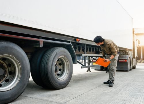 A driver with a clipboard checks their vehicle