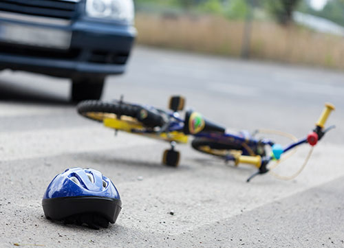 Small bike and a helmet lying on the road